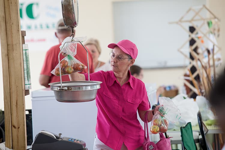 Vendor weighing tomatoes on a scale
